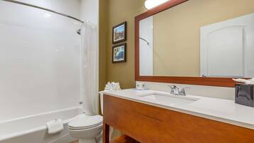A bathroom with a bathtub, toilet, and sink.