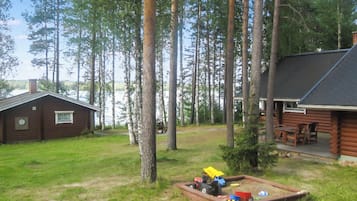 Une cabane avec une terrasse et un petit espace de jeux équipé de jouets.