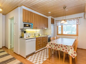 Een koelkast, een magnetron, een vaatwasser, kookgerei, borden en bestek