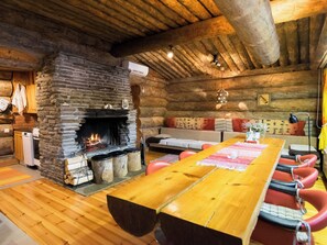 Een sfeervol houten interieur met een stenen open haard, houten meubels en een gezellige zithoek.