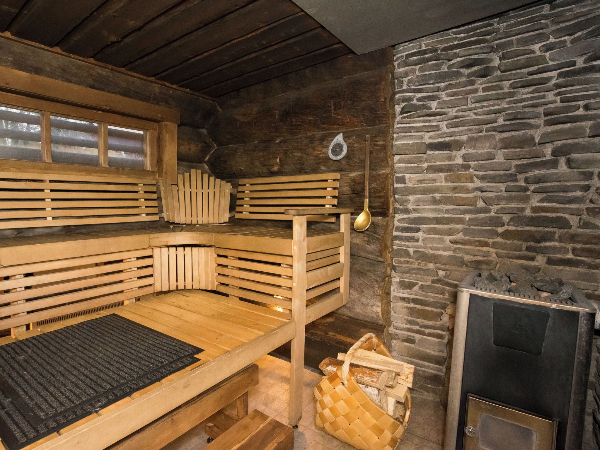A wooden bunk bed room with a stone wall and a fireplace.