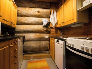 A compact kitchen with wooden cabinets, a dishwasher, and a stove. - Veijon kelo by Interhome (Jyväskylä)
