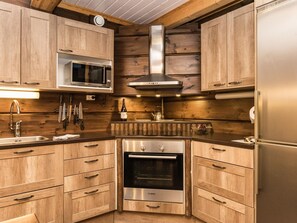 Een koelkast, een magnetron, een vaatwasser, kookgerei, borden en bestek