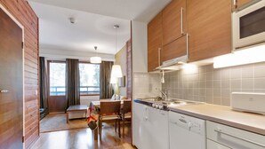 Une cuisine moderne avec des meubles en bois, un four à micro-ondes encastré et un évier.