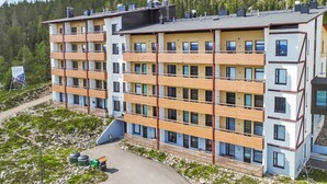 Un hôtel à plusieurs étages au design moderne, doté de balcons et de grandes fenêtres.