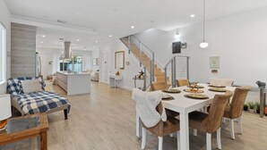 A spacious living area with a dining table set for four, a sofa, and a staircase leading to another level. -  Poolside Sanctuary 4B 4B heated pool ,Jacuzzi 1Gb internet.  (Miami)