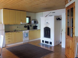 Eine Küche mit Holzausstattung, einer Mikrowelle, einem Herd und einem Kamin.