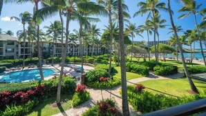Ein Resort mit Schwimmbad, Palmen und Blick auf den Ozean.