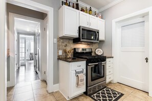 Enjoy cooking in this well-equipped kitchen with a gas stove, microwave, and stainless steel range hood.