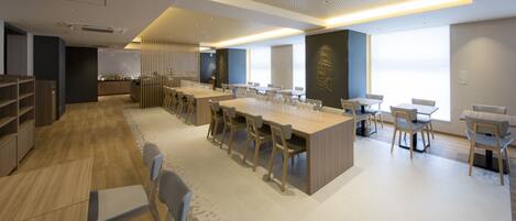 A modern, well-lit dining area with a central island, multiple seating options, and a contemporary design.