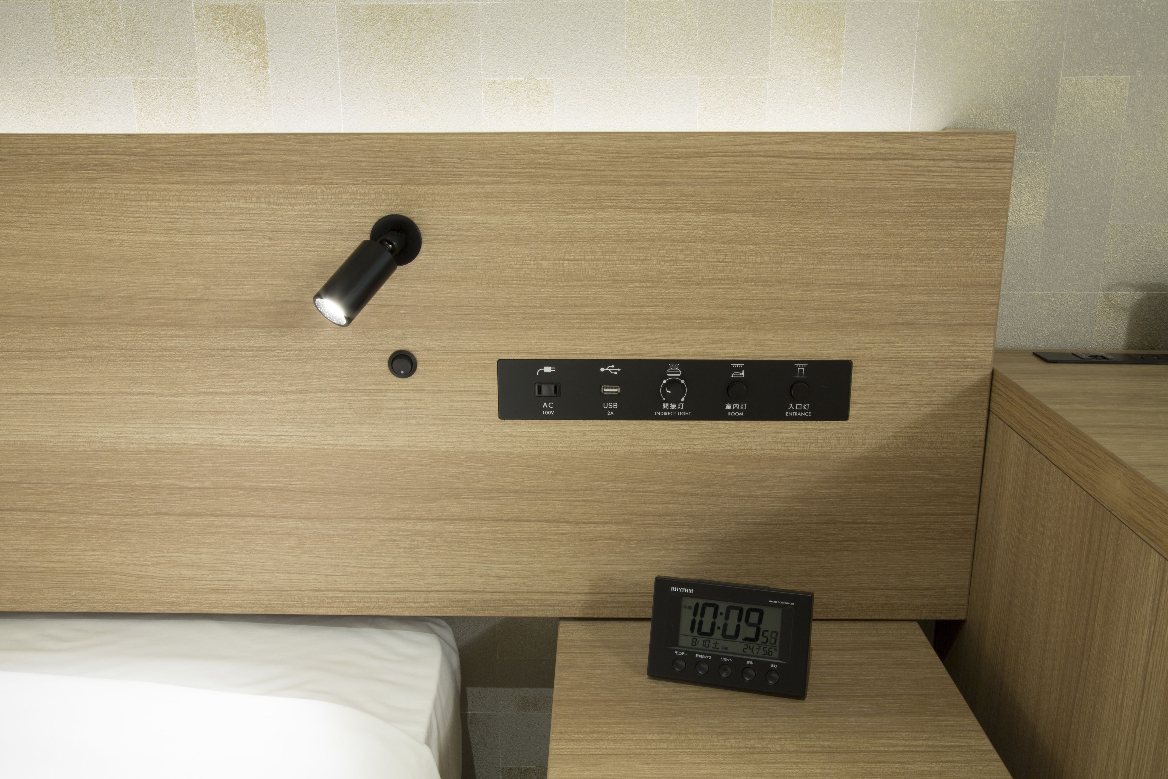 A wooden headboard with a built-in clock and control panel for lighting.