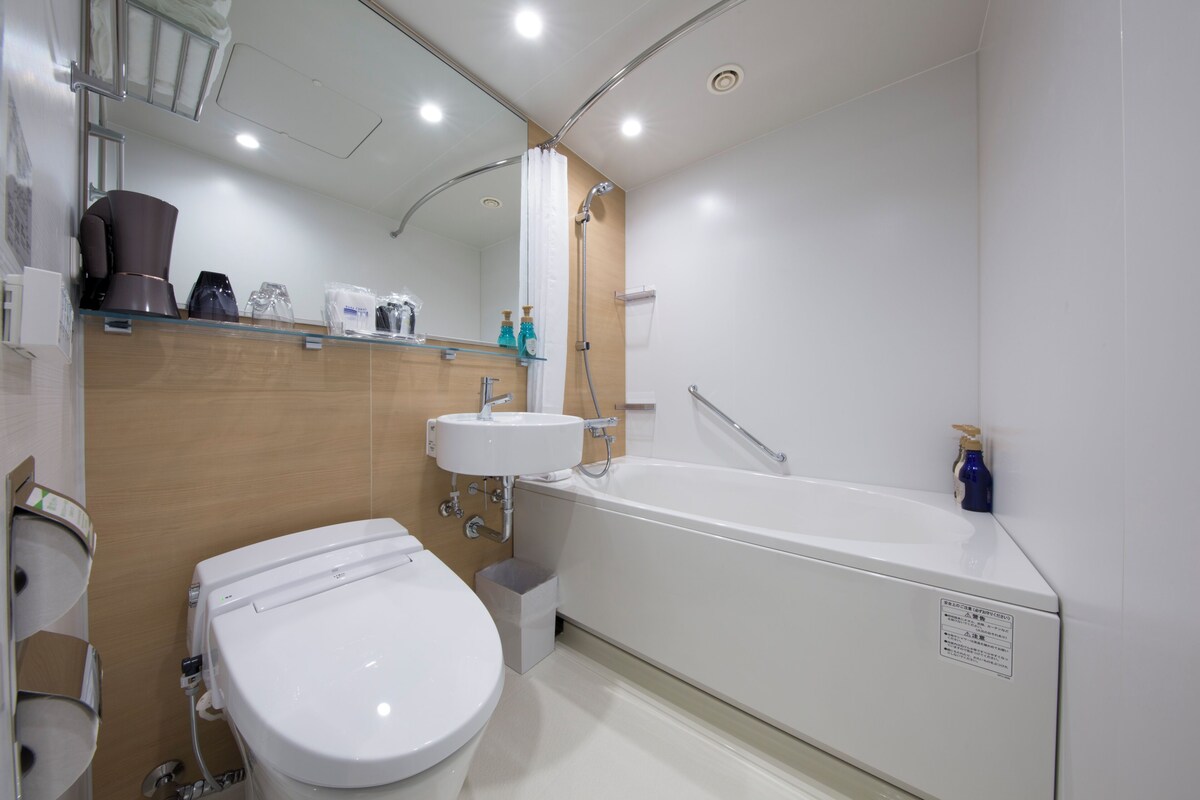 A modern bathroom with a toilet, sink, and bathtub.