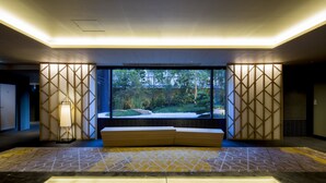 A modern lobby with a large window, geometric wall panels, a bench, and a patterned floor. - Shizutetsu Hotel Prezio Kyoto-Shijo (Kyoto)
