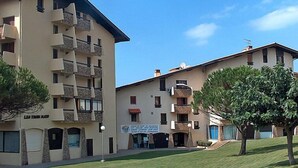 A multi-story hotel with balconies, a sign indicating a restaurant, and a well-maintained lawn. - Trinquart by Interhome (Seignosse)