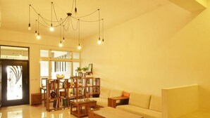Un salon spacieux avec un canapé, une table basse et une bibliothèque en bois.