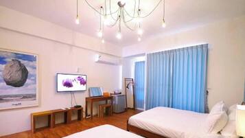 A hotel room with a bed, a desk, a television, and a window with curtains.