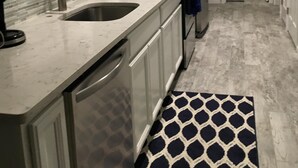 A modern kitchen with white cabinets, a stainless steel sink, a built-in microwave, and a refrigerator. - Cottage by the beach ! Short 120 steps to the beach and its beautiful waiting ! (Mexico Beach)