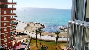 Un immeuble de grande hauteur offrant une vue sur l’océan et une plage rocheuse.