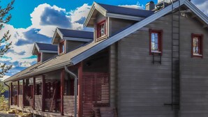 A two-story log cabin with a covered porch and a chimney. - Villa hytönen 1 by Interhome (Äkäslompolo)