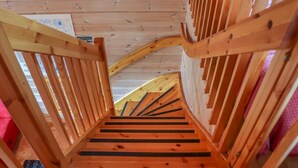 A wooden staircase with a handrail, leading upwards. - Villa hytönen 1 by Interhome (Äkäslompolo)