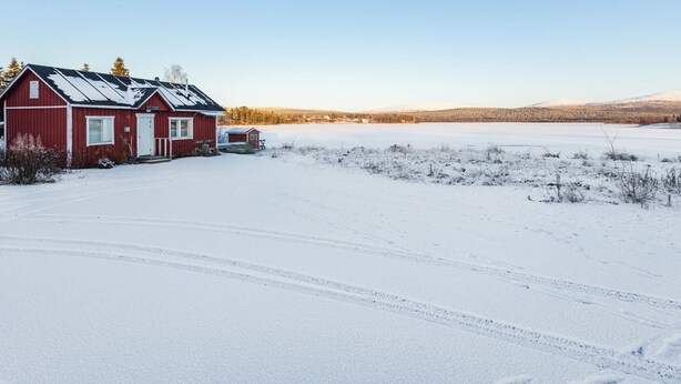 A red cabin with a snow-covered landscape in the background. - Tammukka i by Interhome (Äkäslompolo)