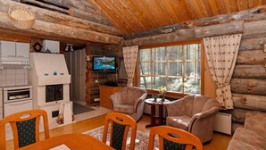 A cozy log cabin interior with a dining area, living room with sofas, a TV, and a fireplace. - Rukanlumous 1 by Interhome (Kuusamo)