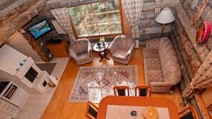 A log cabin interior with a dining area, two sofas, a TV, and a window with curtains. - Rukanlumous 1 by Interhome (Kuusamo)