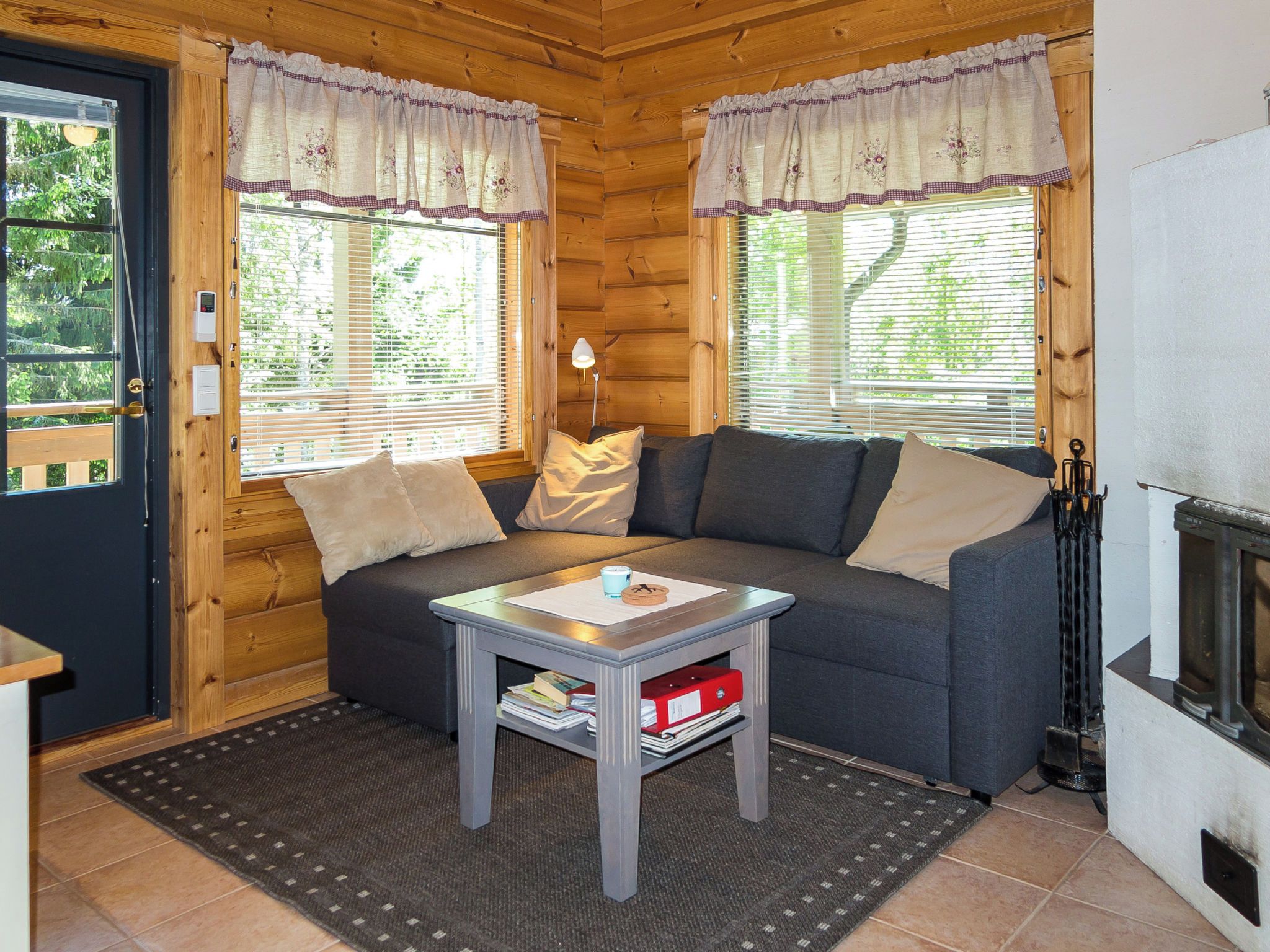 Ein gemütliches Blockhaus-Interieur mit einer Couch, einem kleinen Tisch und einem Kamin.