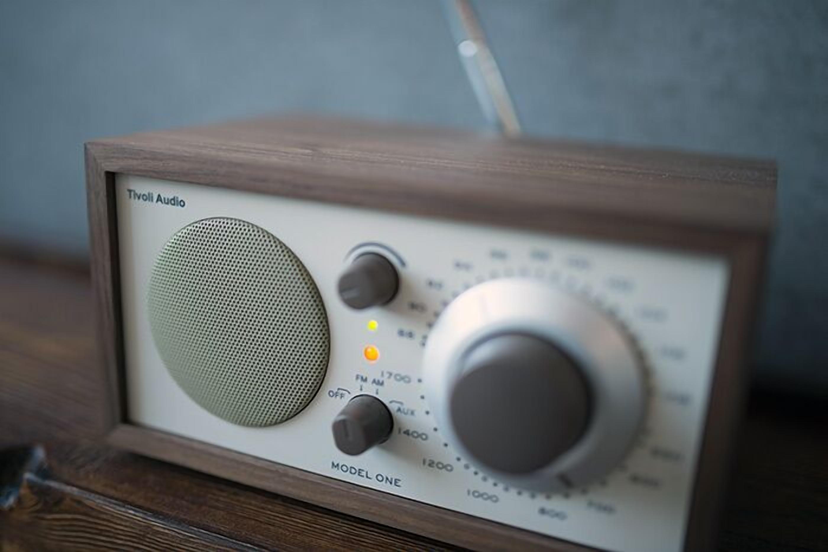 Een vintage radio met houten frame, met de aanduiding 'Tivoli Audio', en een grote speakerrooster.