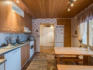 Una cocina con armarios de madera, encimera, estufa y refrigerador.