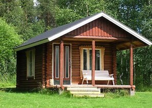 A small wooden cabin with a porch, a bench, and a door. - Vacation home Lehto by Interhome (Taivalkoski)