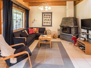 A cozy living room with a fireplace, a sofa, a coffee table, and a television.