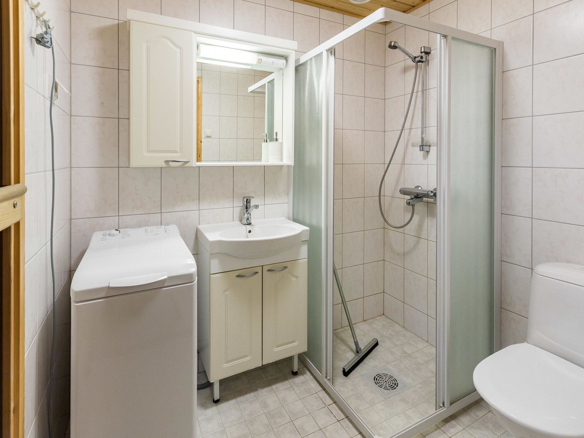 Une salle de bain équipée d’une douche, de toilettes, d’un lavabo et d’un miroir au-dessus du lavabo.