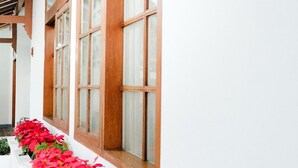 Una hilera de ventanas con marcos de madera y paredes blancas.
