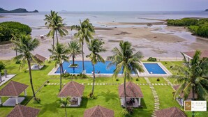 A resort with a swimming pool, beach view, and palm trees. - El Pueblo De Hermano by Cocotel (Lian)