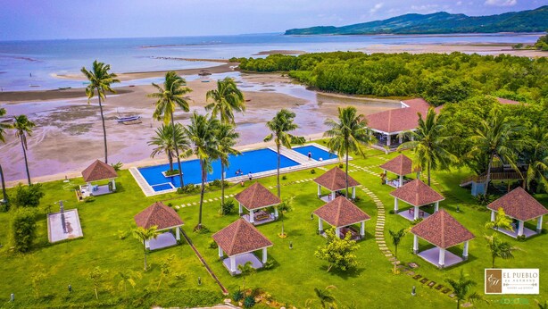 A resort with a large pool, palm trees, and beach views. - El Pueblo De Hermano by Cocotel (Lian)