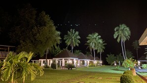 A well-lit resort with multiple overwater bungalows, surrounded by lush greenery and palm trees. - El Pueblo De Hermano by Cocotel (Lian)