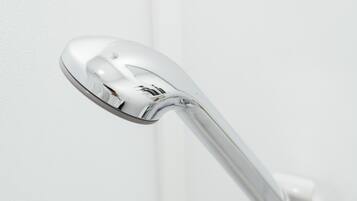 A chrome door handle attached to a white wall.