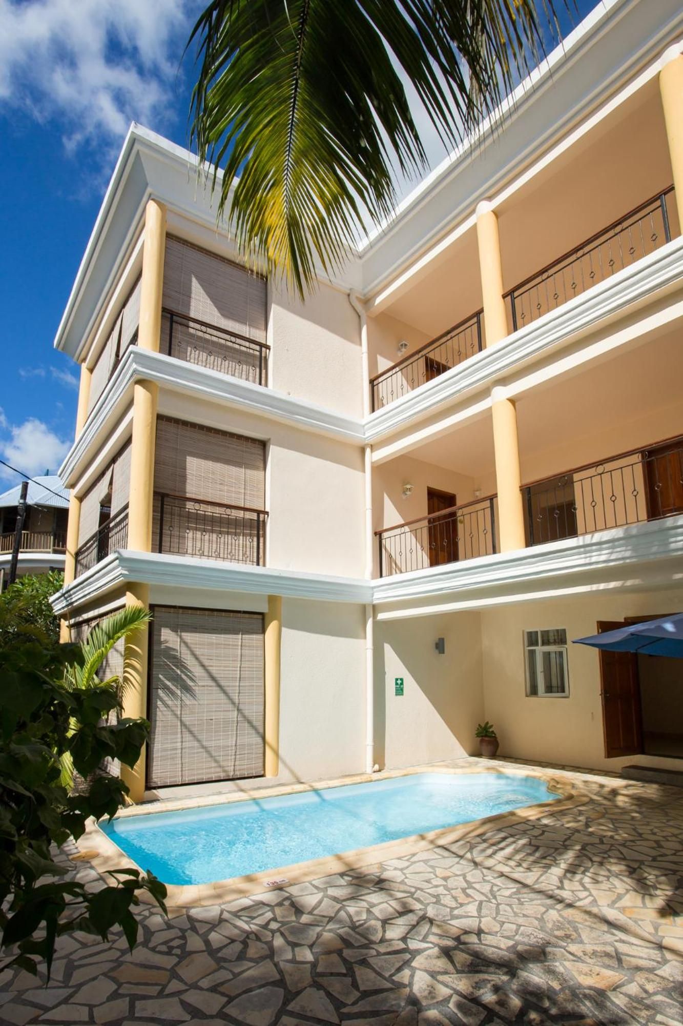 Ein mehrstöckiges Gebäude mit Swimmingpool und einer Terrasse mit Steinplatten.