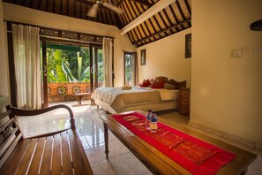 A room with a bed, a bench, and a red runner. - Bali Asli Lodge by EPS (Ubud)
