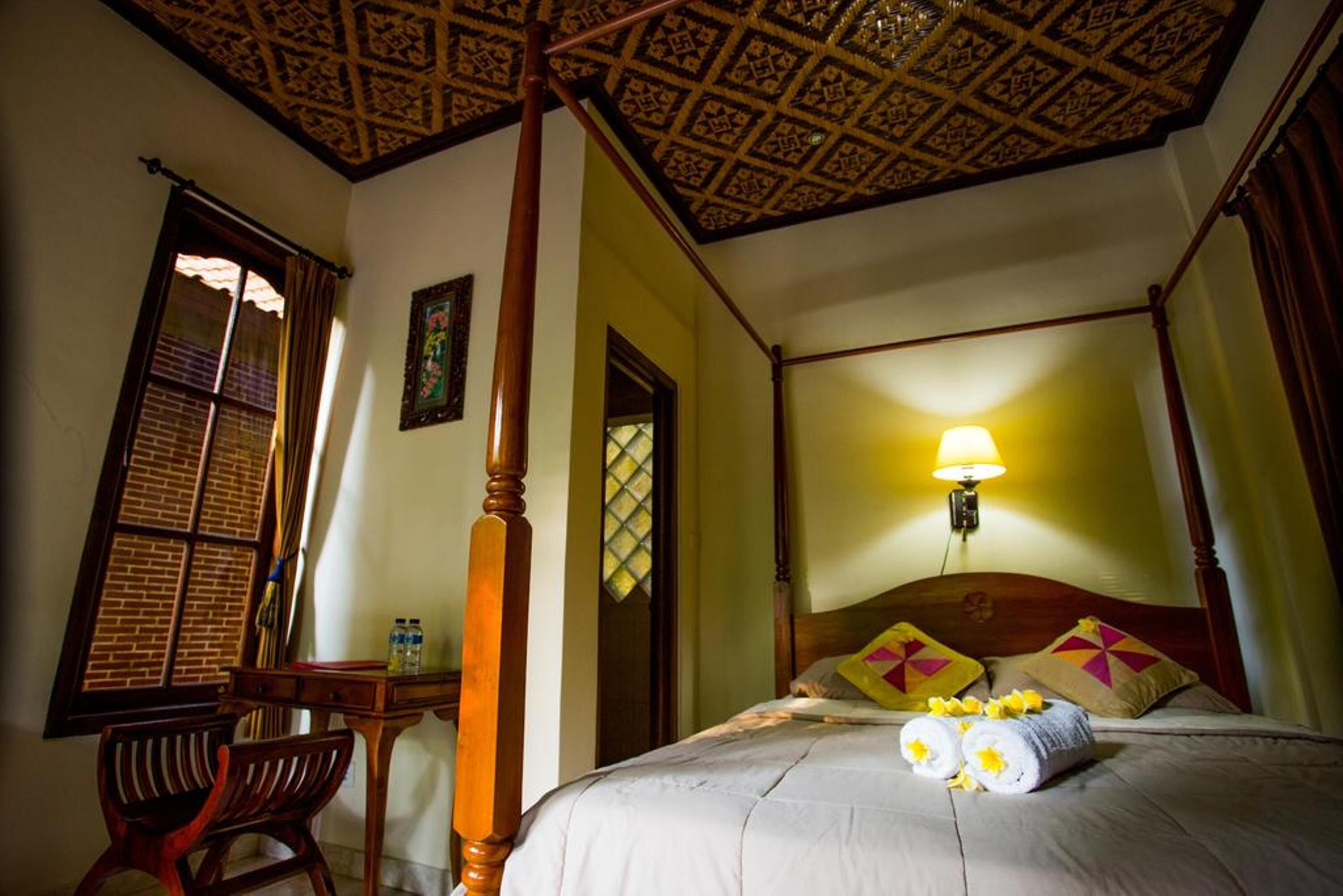 Ein traditionell eingerichteter Raum mit Himmelbett, Schreibtisch und Stuhl.