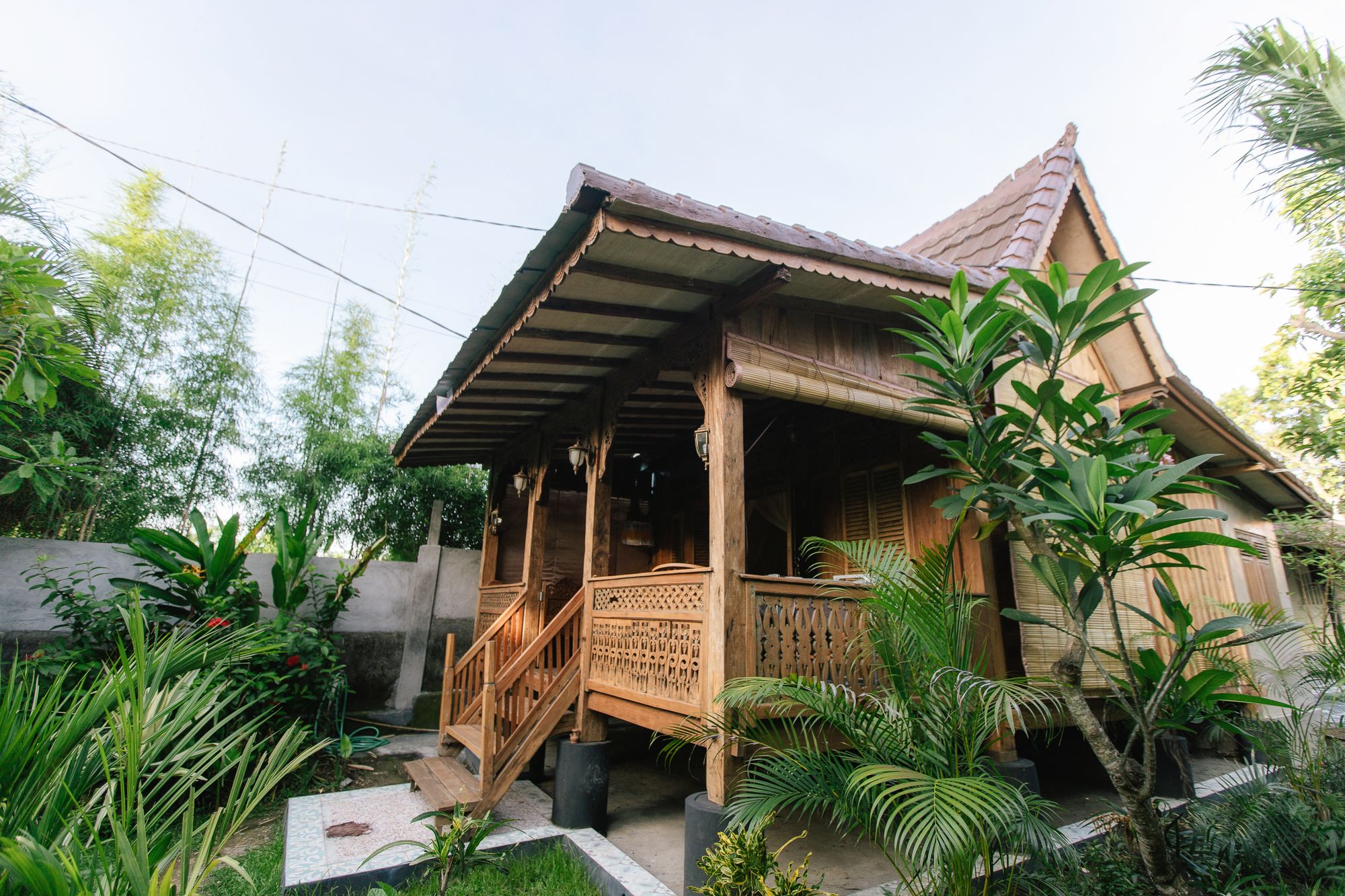 A traditional wooden house with a tiled roof and a porch.