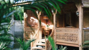 A wooden structure with a porch, a bench, and a table. - Pande Homestay (Canggu)