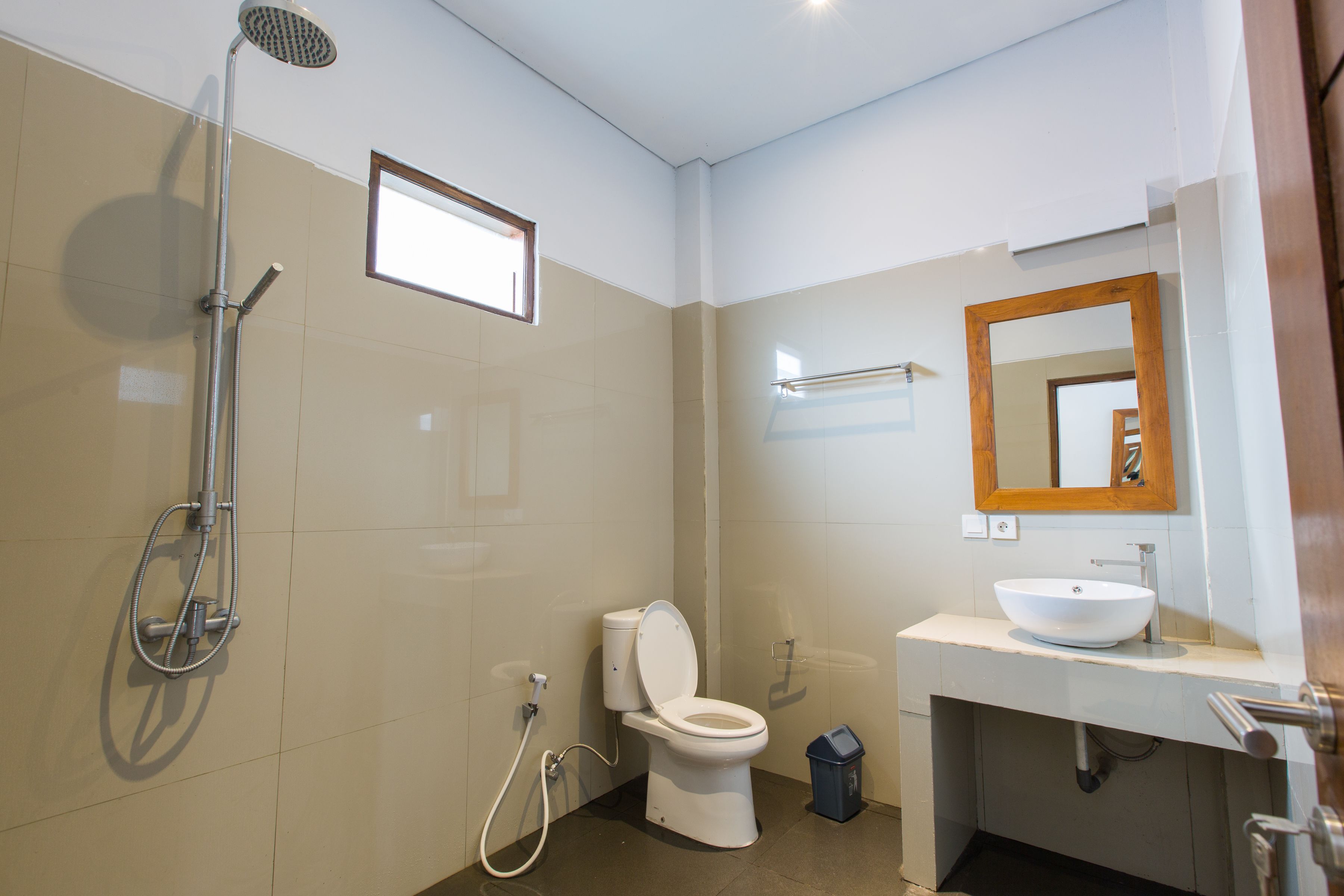 Un baño moderno con inodoro, lavamanos y ducha.