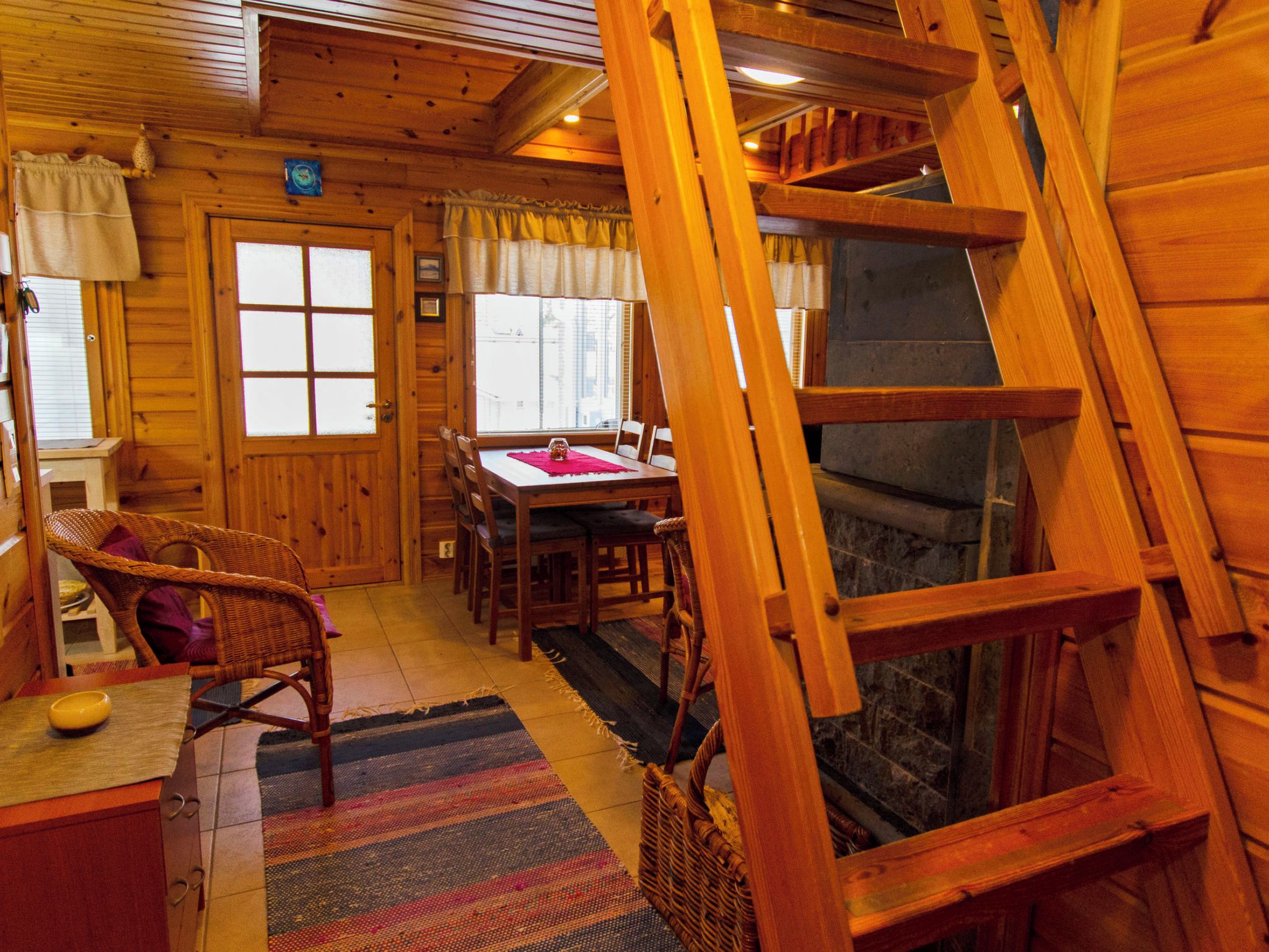 Un intérieur en bois comprenant un coin repas, un escalier et une cheminée.