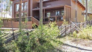 A two-story wooden cabin with large windows, a balcony, and a staircase leading to the upper level. - Pielislinna/loma-koli by Interhome (Lieksa)