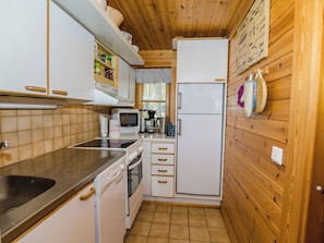 Una cocina compacta con microondas, estufa y refrigerador.