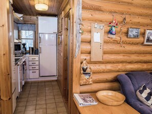 A compact kitchen with a refrigerator, a coffee maker, and a toaster.