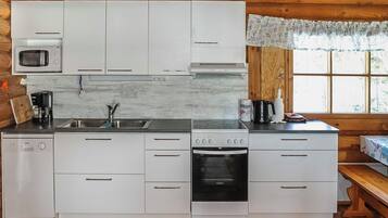 A compact kitchen with white cabinetry, a microwave, a coffee maker, and a built-in oven.