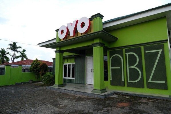 A building with a green facade and a sign that reads "OYO".